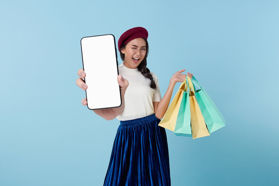 A woman holding a tablet computer and shopping bags